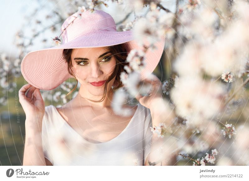 Frau in der geblühten Zeit des Feldes im Frühjahr Stil Glück schön Gesicht Mensch Erwachsene Natur Baum Blume Blüte Park Mode Kleid Hut brünett rosa weiß
