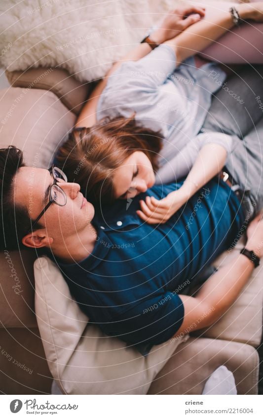 Paare, die auf Couch zusammen fernsieht legen Freude Glück Erholung Freizeit & Hobby Haus Wohnzimmer Mensch Junge Frau Jugendliche Junger Mann Erwachsene 2