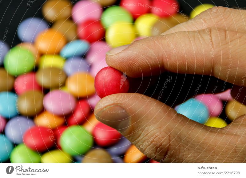 Die Rote Süßwaren Gesundheit Alternativmedizin Mann Erwachsene Hand Finger festhalten mehrfarbig rot Schokolinsen Tablette Sucht nehmen wählen Auswahl Farbfoto