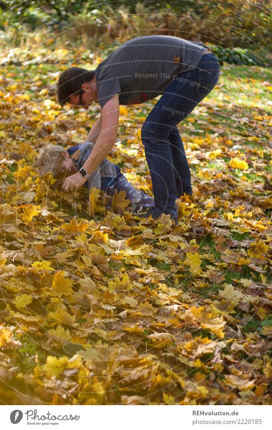 Mann spielt mit Kind im Herbstlaub Schwache Tiefenschärfe Unschärfe Sonnenlicht Tag Textfreiraum links Außenaufnahme Farbfoto Bewegung Lebensfreude