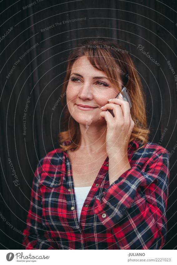 Reife Frau hat ein Gespräch auf ihrem Smartphone Landwirt Kommunizieren Mitteilung Cowgirl Schwache Tiefenschärfe einzigartig reif Erwachsene Handy authentisch