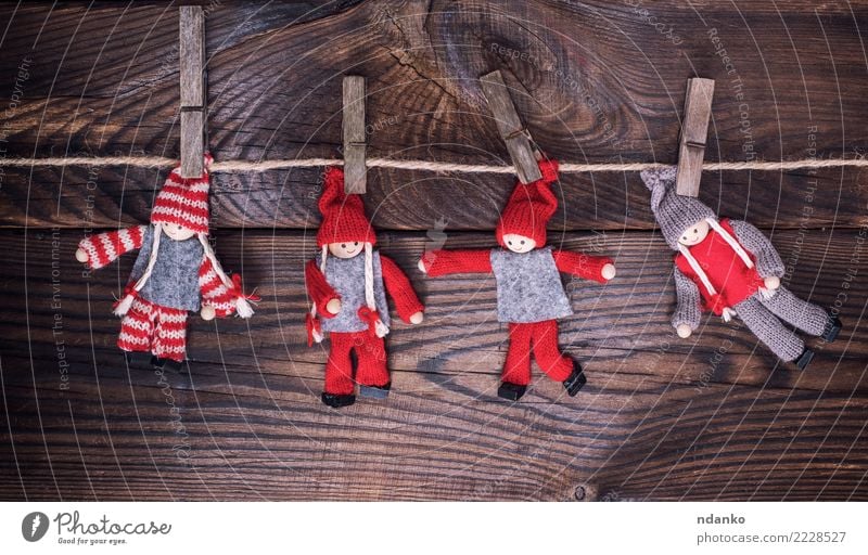 Holzpuppen in Winterkleidung Weihnachten & Advent Silvester u. Neujahr Seil Spielzeug Puppe klein braun rot erhängen Wäscheklammern Hintergrund altehrwürdig
