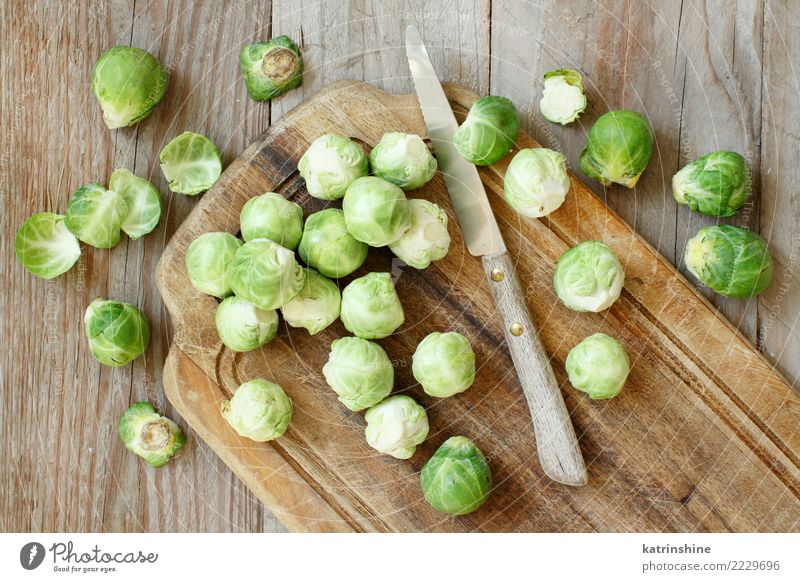 Rosenkohl auf einem hölzernen Brett mit einem Messer Gemüse Ernährung Vegetarische Ernährung Diät Tisch Gastronomie frisch hell natürlich retro braun grün