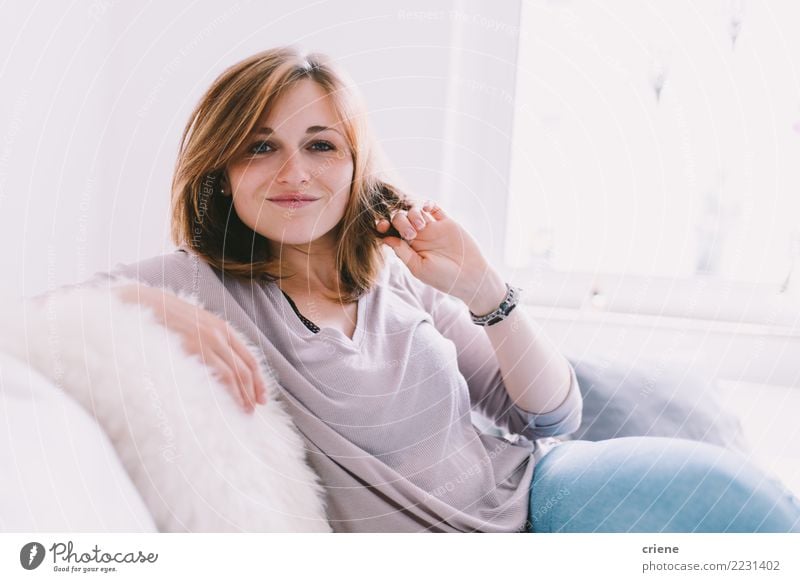 Portrait der lächelnden kaukasischen Frau zu Hause Freude Glück Erholung Freizeit & Hobby Sofa Wohnzimmer Erwachsene Jugendliche Lächeln sitzen hell