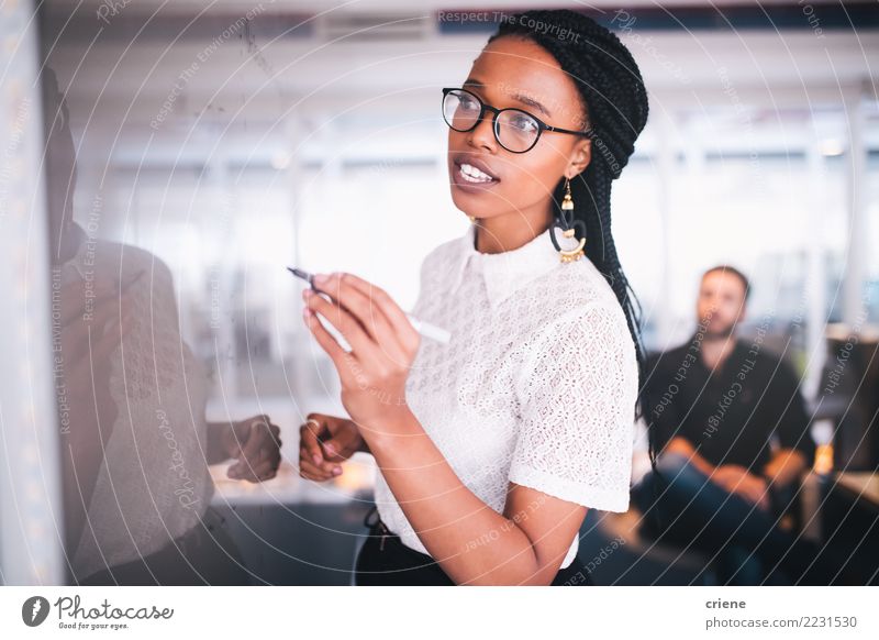 Junge afrikanische Geschäftsfrauschreibensanmerkungen über whiteboard Erfolg Praktikum Arbeit & Erwerbstätigkeit Büro Kapitalwirtschaft Business Sitzung