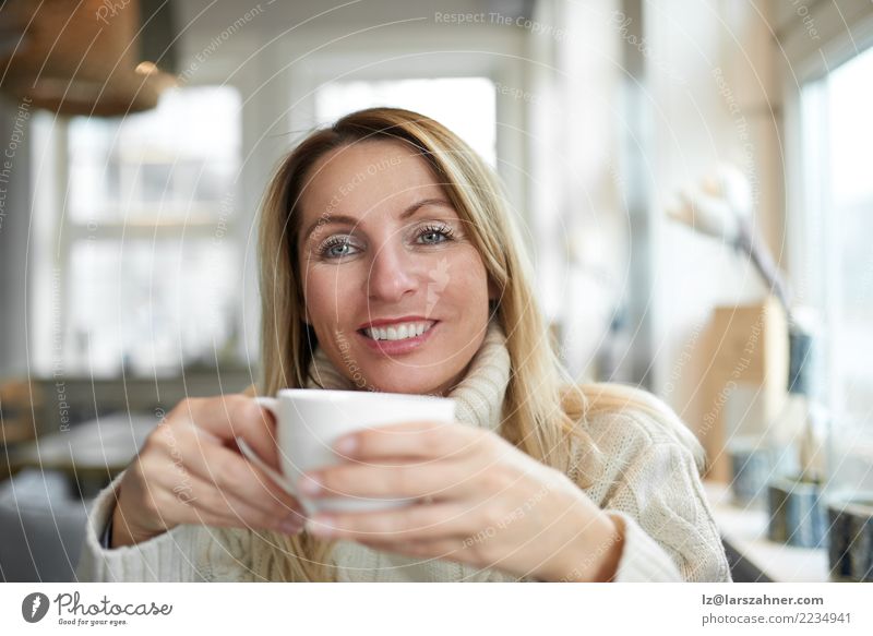 Schönheit, die sich zu Hause mit Kaffee entspannt Getränk trinken Tee Glück Gesicht ruhig Wohnzimmer Frau Erwachsene 1 Mensch 30-45 Jahre blond Lächeln