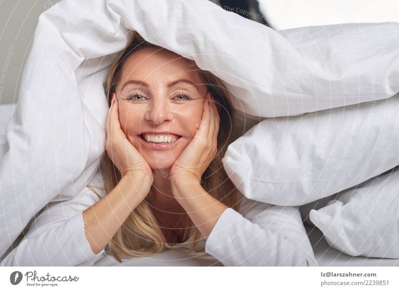 Schöne Frau von mittlerem Alter unter Blättern Glück schön Haut Gesicht Erholung Schlafzimmer Erwachsene 1 Mensch 45-60 Jahre blond Lächeln schlafen