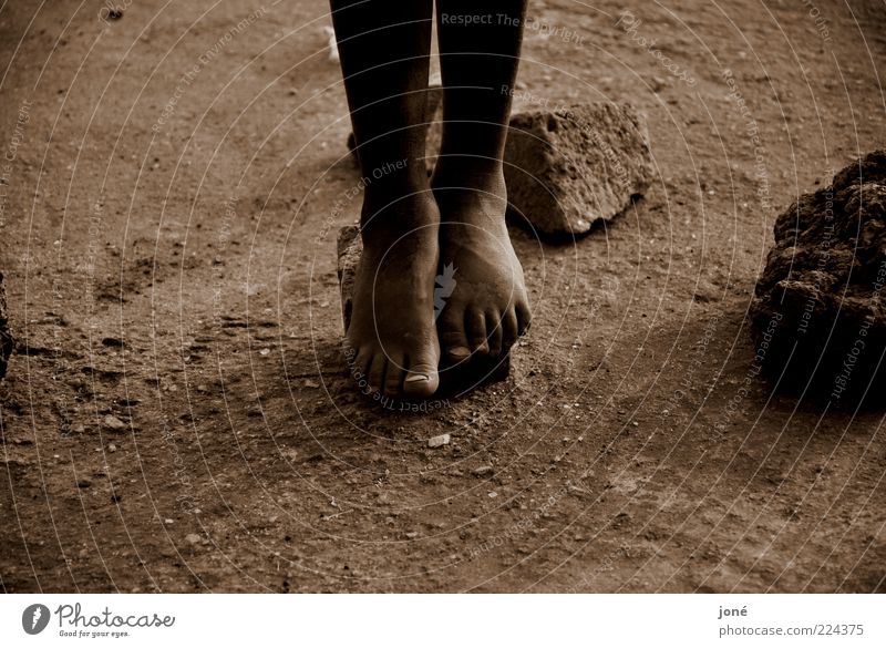 Kinderfüße/Ruanda Spielen Ferne Mensch Kindheit Beine Fuß 1 Erde Stein Armut eckig braun Mitgefühl Hoffnung Trauer schuldig Stress Sepia Farbfoto Außenaufnahme