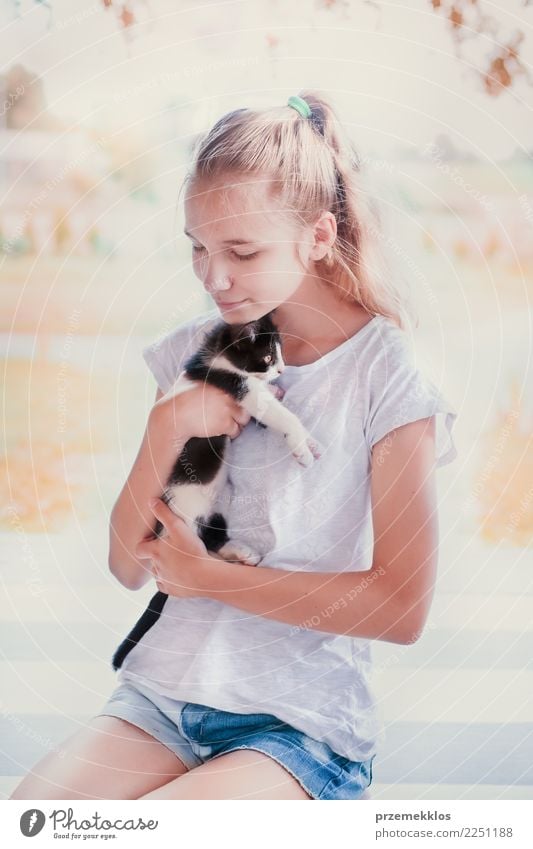 Schönes Mädchen, das auf dem Portal hockt und ihre kleine Katze umarmt Lifestyle Glück Sommer Sonne Sonnenbad Mensch Junge Frau Jugendliche Erwachsene