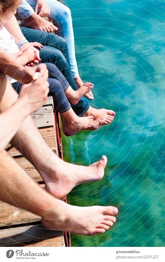 Nahaufnahme der Beine Familie verbringen Zeit zusammen sitzen auf Steg über den See in der Sommerzeit Freude Glück Erholung Freizeit & Hobby