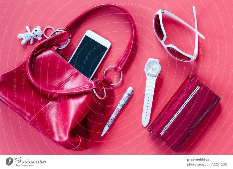 Rote und weiße Dinge zogen aus roter Handtasche Lifestyle elegant Stil Zufriedenheit Telefon Handy PDA Accessoire Schreibstift beobachten oben Tasche Brille