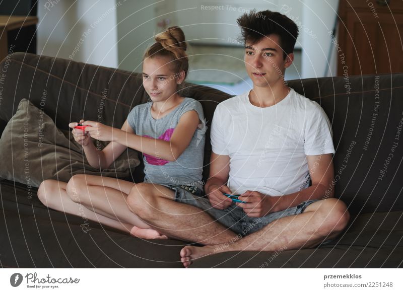 Konzentrierte Jungen und Mädchen, die zu Hause auf dem Sofa sitzend Videospiele spielen Lifestyle Freude Freizeit & Hobby Spielen Häusliches Leben Kind