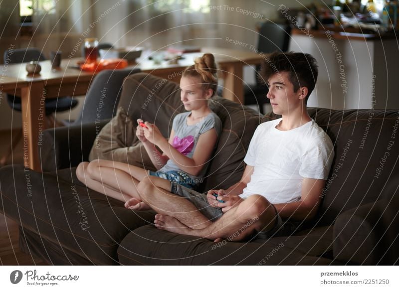Junge und Mädchen, welche die Videospiele zu Hause sitzen auf Sofa spielt Lifestyle Freude Freizeit & Hobby Spielen Kind Technik & Technologie Junge Frau