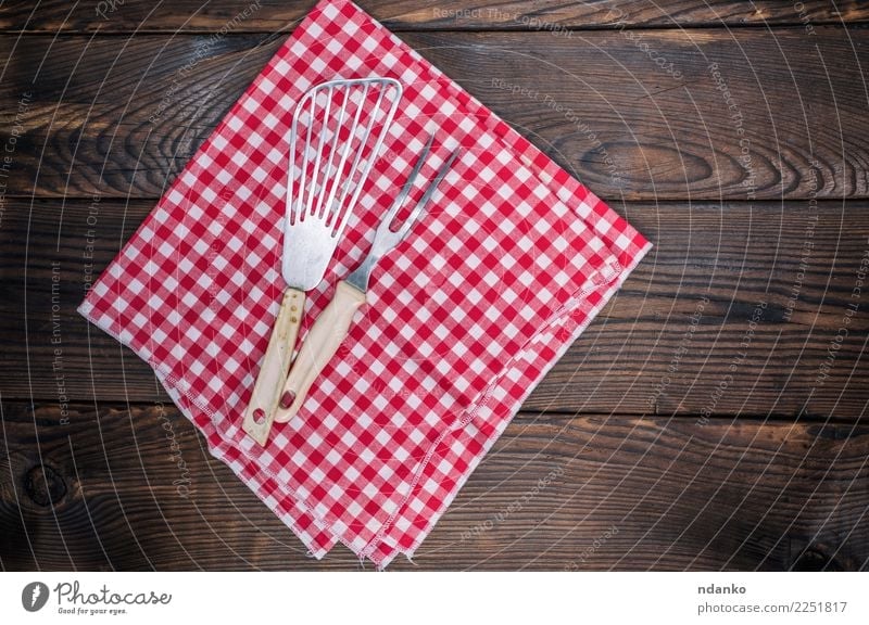 Vintage Küchengeräte auf einer roten Serviette Besteck Gabel Tisch Stoff Holz retro braun weiß Deckung Picknick leer Speisekarte Textil Tischwäsche Konsistenz