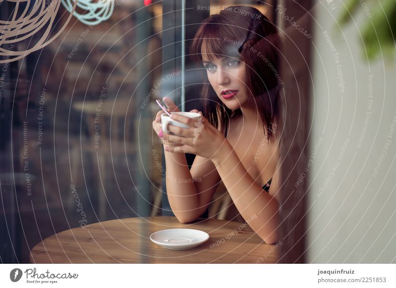 Schönheitsmädchen, das in einer Kaffeestube mit einer Schale in ihren Händen sitzt Lifestyle schön Gesicht Tisch Business Frau Erwachsene Straße sitzen modern