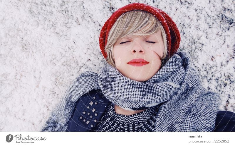Junge Frau, die sich über einem schneebedeckten Boden hinlegt Lifestyle Stil schön Wellness harmonisch Sinnesorgane Erholung Winter Schnee Winterurlaub