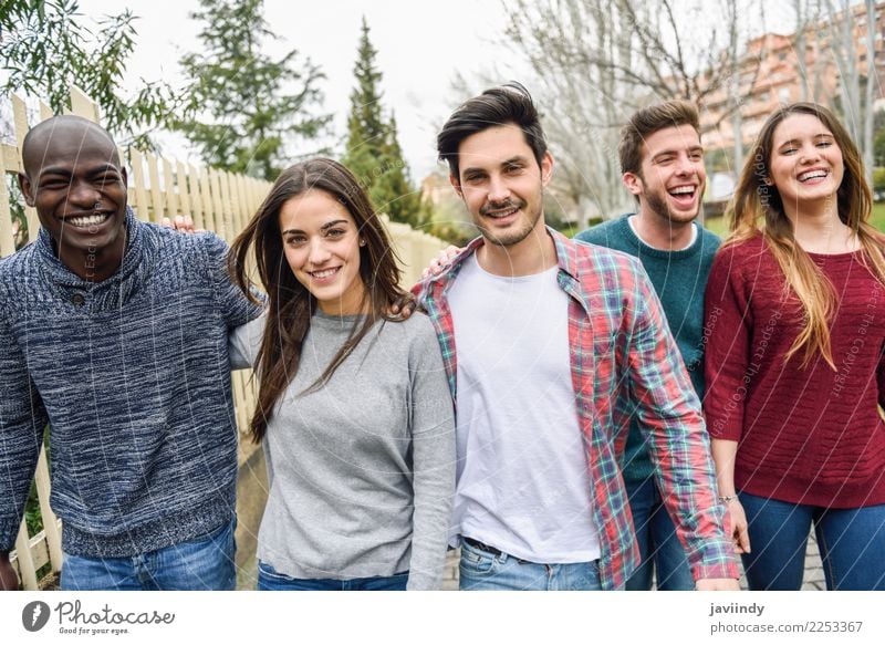 Eine Gruppe multiethnischer junger Menschen lacht gemeinsam im Freien vor einem städtischen Hintergrund. Lifestyle Freude Glück Junge Frau Jugendliche