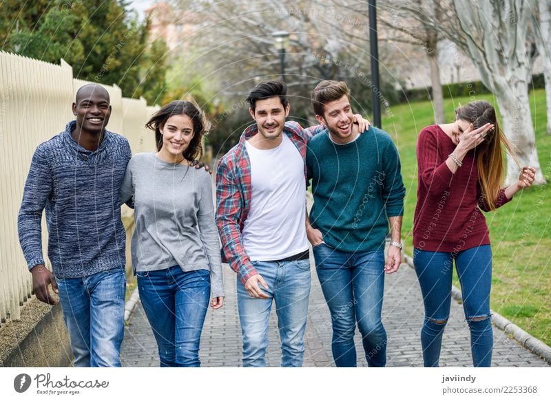 Eine Gruppe multiethnischer junger Menschen, die sich gemeinsam im Freien vor einem städtischen Hintergrund vergnügen. Lifestyle Freude Glück Junge Frau