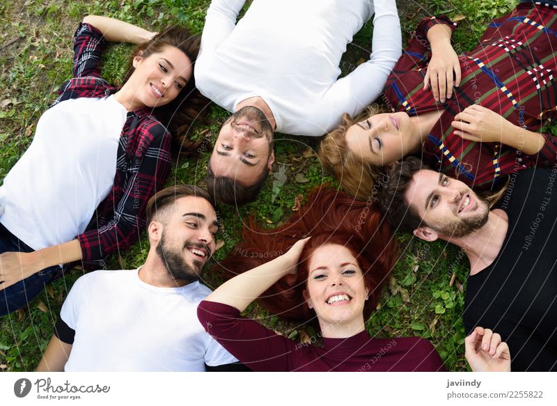 Frauen und Männer liegen im Gras und tragen legere Kleidung. Lifestyle Freude Glück schön Mensch maskulin feminin Junge Frau Jugendliche Junger Mann Erwachsene