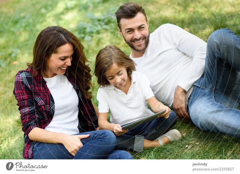 Glückliche Familie in einem städtischen Park, der mit Tablettencomputer spielt Lifestyle Freude schön Spielen Sommer Kind Computer Technik & Technologie Mensch
