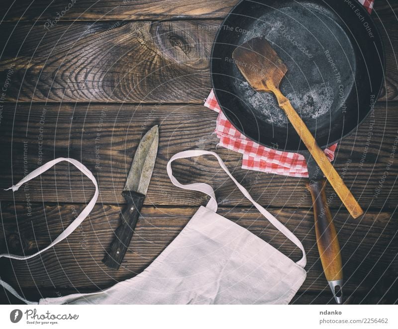 leere schwarze Gusseisenbratpfanne Pfanne Messer Tisch Küche Holz Metall alt dunkel natürlich retro braun Tradition altehrwürdig bügeln Aussicht Hintergrund