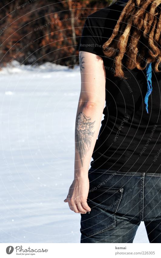 One cold arm Lifestyle Winter Schnee Mensch Frau Erwachsene Leben Haare & Frisuren Arme Hand Gesäß 1 Tattoo T-Shirt Jeanshose brünett Rastalocken Dreadlocks