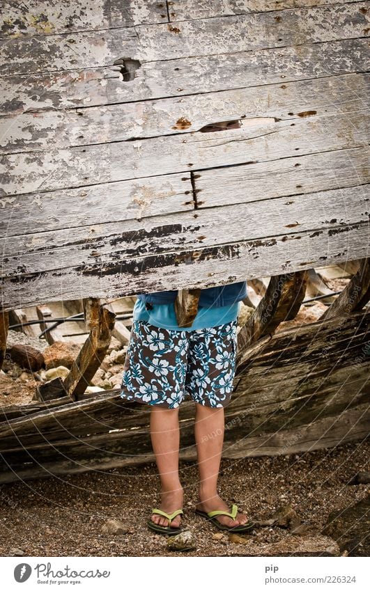 beinfreiheit Mensch Junge Beine Fuß 1 Bermudashorts Flipflops Holz Metall Rost Blick stehen alt dreckig Langeweile Schlitz Spalte Schiffswrack Wasserfahrzeug