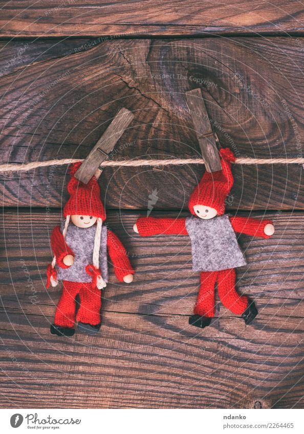 zwei Holzpuppen hängen an einem Seil, Kind Spielzeug Puppe klein braun rot erhängen Wäscheklammern Weihnachten Hintergrund altehrwürdig rustikal Farbfoto