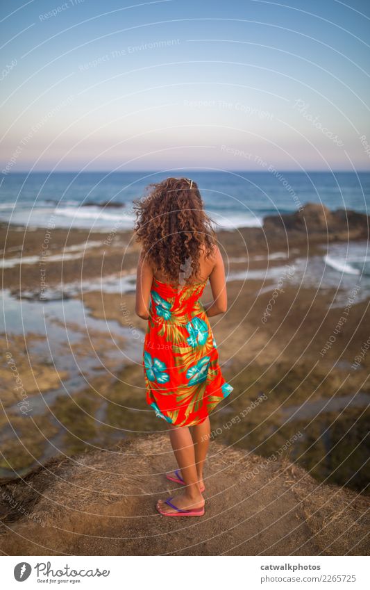 Mädchen mit langen lockigen Haaren, die von der Klippe in den Ozean schauen. Lifestyle elegant Ferien & Urlaub & Reisen Tourismus Abenteuer Freiheit Sommer