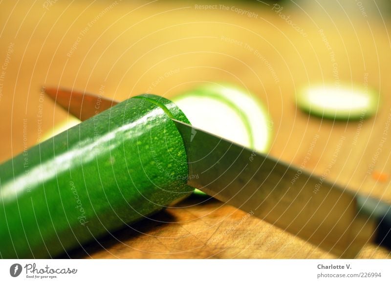 Zucchini schnippeln Lebensmittel Gemüse Ernährung Vegetarische Ernährung Messer braun grün geschnitten zerkleinern Scheibe Holzbrett Metall Schneidebrett