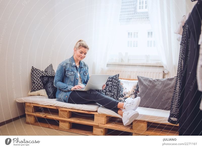 Junge Frau, die auf diy Couch mit Notizbuch sitzt Lifestyle kaufen Freizeit & Hobby Innenarchitektur Sofa Raum Wohnzimmer Handy Technik & Technologie