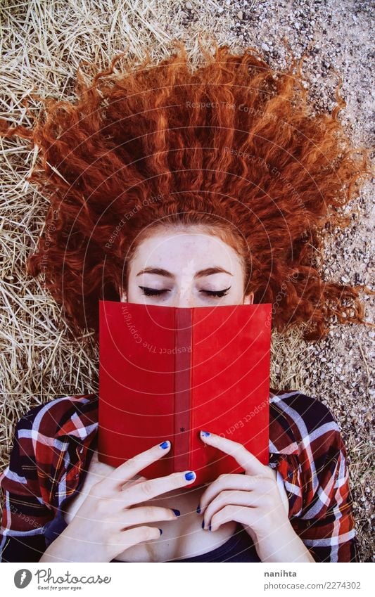 Junge Rothaarigefrau, die ein rotes Buch liest Lifestyle Stil schön Wohlgefühl Sinnesorgane Erholung Freizeit & Hobby lesen Bildung Schüler Mensch feminin
