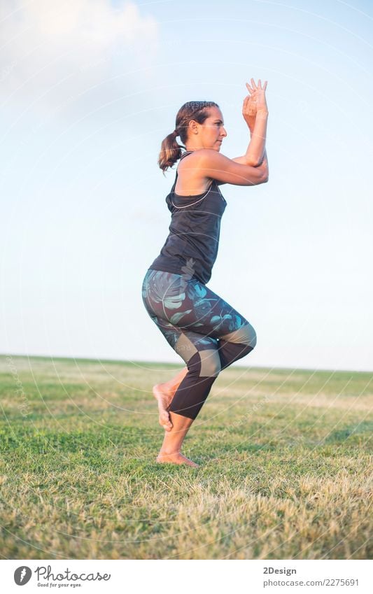 Schönes Mädchen nimmt an Yoga im Park teil Lifestyle harmonisch Erholung Sport Frau Erwachsene Jugendliche Natur Gras sitzen grün Kraft Konzentration