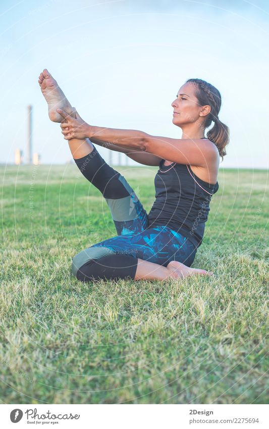 Schönes Mädchen nimmt an Yoga im Park teil Lifestyle harmonisch Erholung Sport Frau Erwachsene Jugendliche Natur Gras sitzen grün Kraft Konzentration