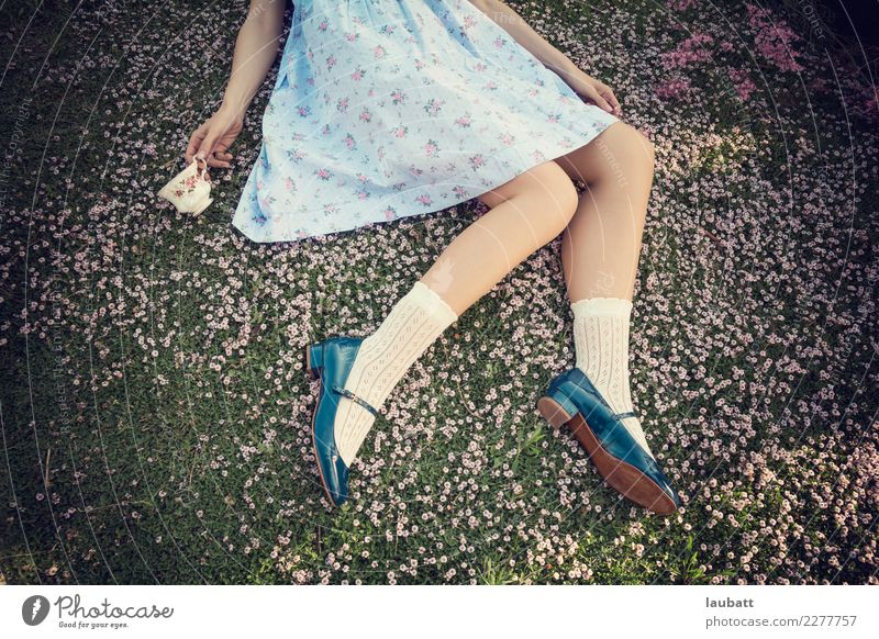 Wunderland Lifestyle Stil Design Freude Junge Frau Jugendliche Beine Fuß Buch lesen Natur Blume Gras Blüte Wiese Spielzeug Puppe Tasse Porzellan liegen