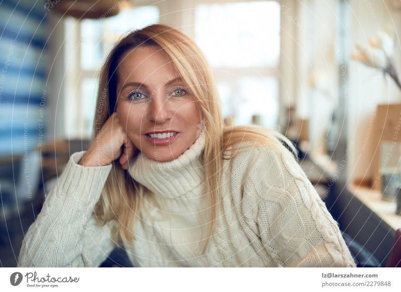 Portrait einer schönen Frau, die Kamera betrachtet trinken Kaffee Tee Topf Glück Gesicht ruhig Freizeit & Hobby Winter Tisch Erwachsene 1 Mensch 45-60 Jahre
