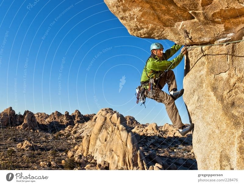 Kletterer, der sich an eine Klippe klammert. Abenteuer Freiheit Berge u. Gebirge Klettern Bergsteigen Erfolg Seil 1 Mensch Natur Landschaft Gipfel hängen