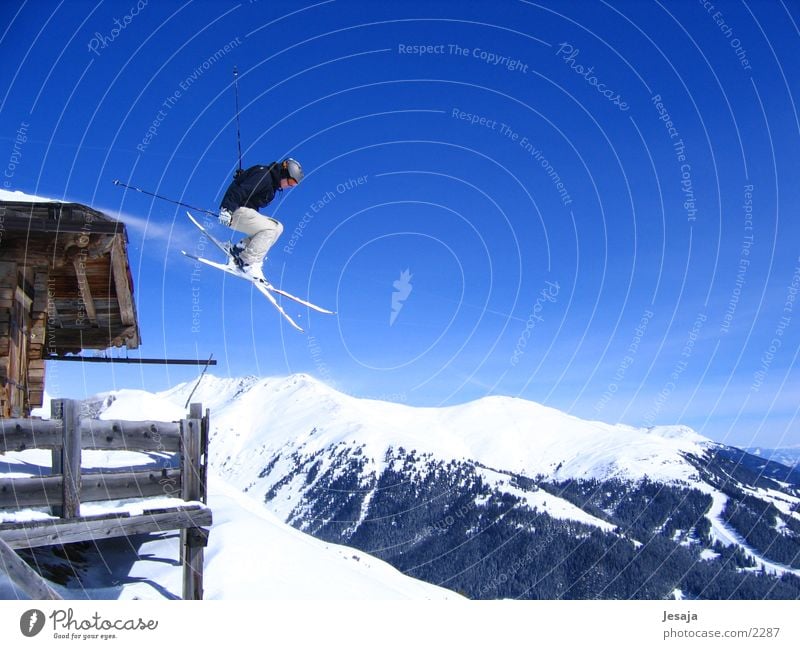 Über die Alpen Ferien & Urlaub & Reisen Winter Schnee Berge u. Gebirge Sport Sportler Skifahren Himmel Hütte Fitness springen Unendlichkeit sportlich blau weiß