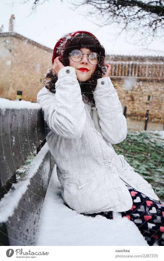 Junge Frau genießt einen verschneiten Tag und sitzt auf einer Bank. Lifestyle Stil Wellness Sinnesorgane Erholung Mensch feminin Jugendliche 1 18-30 Jahre