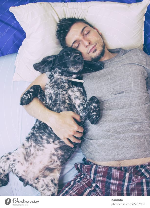 Junger Mann, der mit seinem Hund schläft Lifestyle Wellness harmonisch Wohlgefühl Erholung Bett Mensch maskulin Jugendliche Erwachsene 1 30-45 Jahre Nachthemd