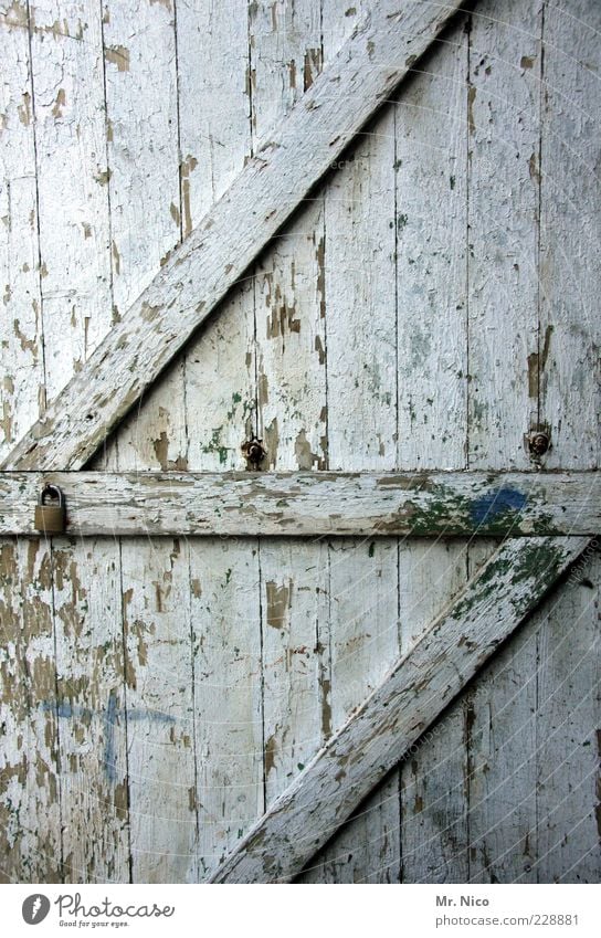 der lack ist ab Hütte Ruine Bauwerk Tür alt dreckig kaputt Holztür Lagerschuppen Scheunentor weiß abblättern verfallen antik Holzbrett Maserung Vergänglichkeit