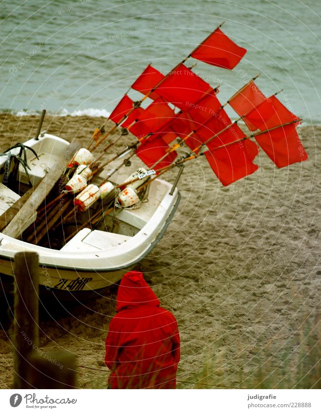 Rot am Strand Mensch 1 Umwelt Natur Landschaft Klima Küste Ostsee Meer Fischerboot sitzen warten rot Stimmung Fahne Kapuze Regenjacke Farbfoto Außenaufnahme Tag