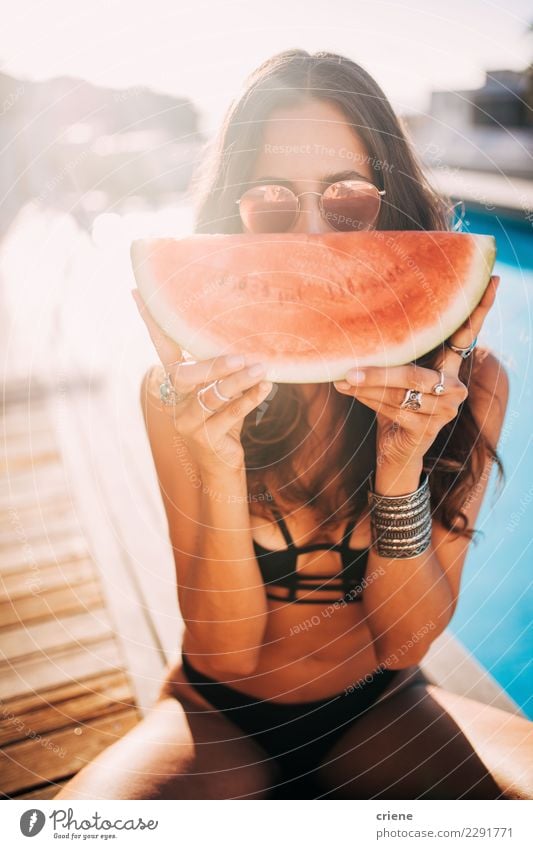 Frau, die Wassermelone am Sommertag am Swimmingpool genießt Frucht Essen Lifestyle Schwimmbad Ferien & Urlaub & Reisen Erwachsene Jugendliche Sonnenbrille