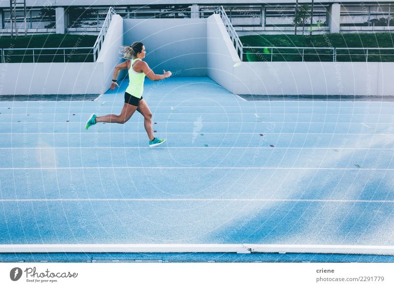 Weiblicher kaukasischer Athlet, der auf blauer Laufbahn läuft Sport Fitness Geschwindigkeit rennen schnell üben Wettbewerb Sportbekleidung Farbfoto mehrfarbig