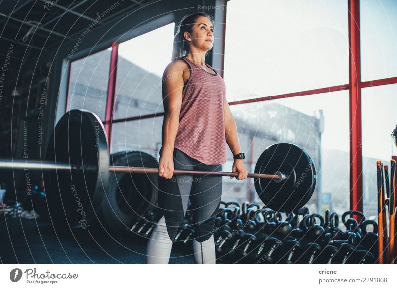 Geeignete junge erwachsene Frau, die mit Barbell in der Turnhalle trainiert Lifestyle Freizeit & Hobby Sport Fitness Sport-Training Erwachsene passen üben