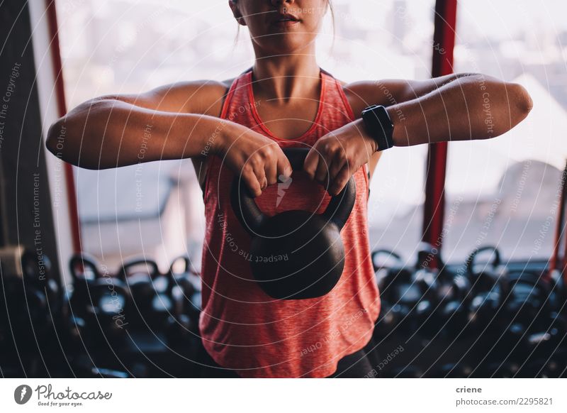 Muskulöse Sitzfrau, die Training mit kettlebell in der Turnhalle tut Lifestyle Körper Mensch Frau Erwachsene Fitness weiß Kettlebell Wasserkessel Klingel