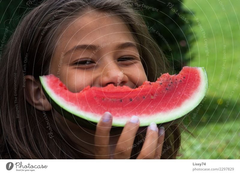 Lächelndes Mädchen mit einer angebissenen Melone vor dem Mund Freude Sommer Garten Kind Kindheit 1 Mensch 8-13 Jahre brünett Essen lachen Fröhlichkeit Glück