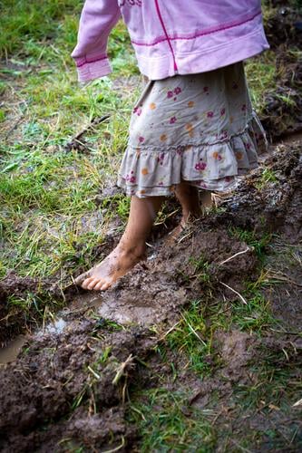 Kindheit Spielen Kindererziehung feminin Mädchen Körper 1 Mensch 3-8 Jahre Sommer Herbst Wiese schlammig Rock gehen Armut authentisch nass natürlich positiv