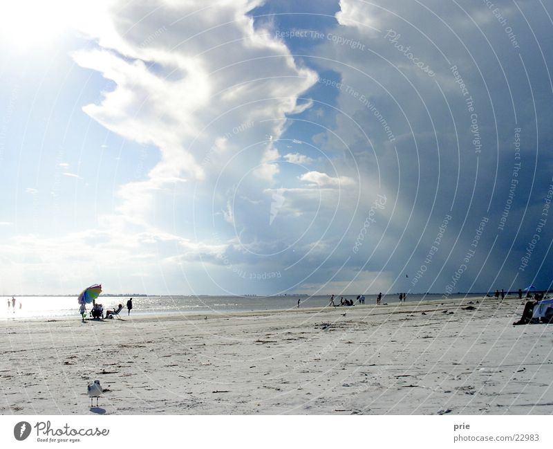 Aufbruchsstimmung Sturm Wolken Strand Meer Sand Regenschirm Sonne Gewitter