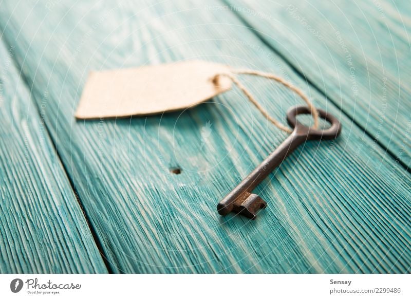 Alter rostiger Schlüssel mit einem Papieraufkleber auf dem hölzernen Brett Schreibtisch Tisch Erfolg Business Seil Holz Metall Rost alt authentisch neu retro
